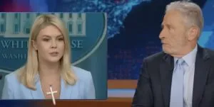 Karoline Leavitt Ditches Cross Necklace After Jon Stewart’s Viral Jab Faith, Politics, and Satire Collide